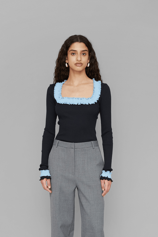 Woman wearing a black top with light blue accents