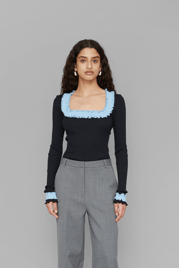 Woman wearing a black top with light blue accents 